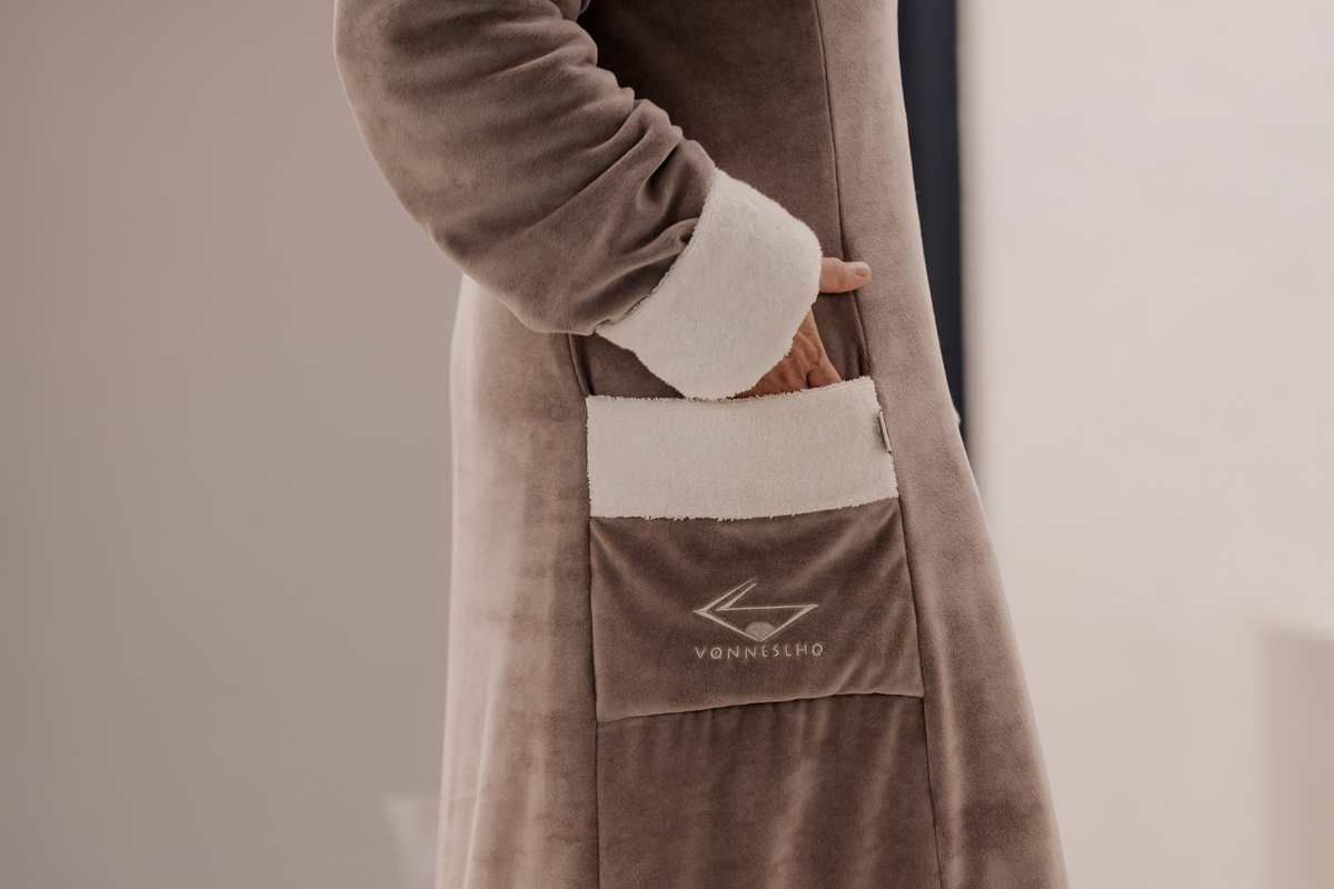 VONNESLHO Charmant Bademantel in Schlamm (Braun) – Detail der Tasche mit cremefarbenem Besatz und gesticktem Logo